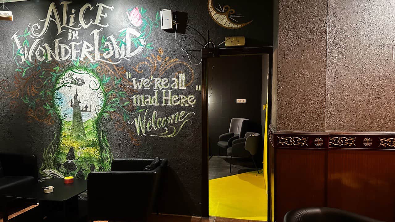 Parete dipinta a tema Alice nel Paese delle Meraviglie presso il club della cannabis Alice Valencia