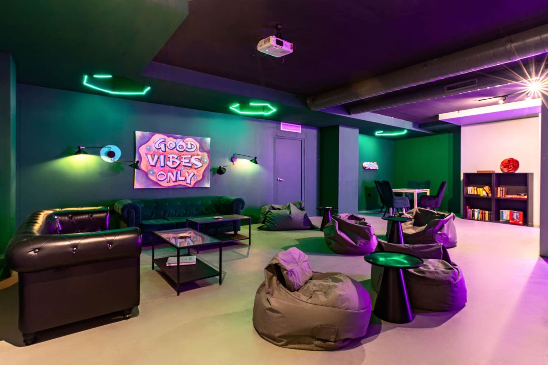 Zona lounge accogliente del club della cannabis Gusto Green a Barcellona con poltrone sacco e luci al neon