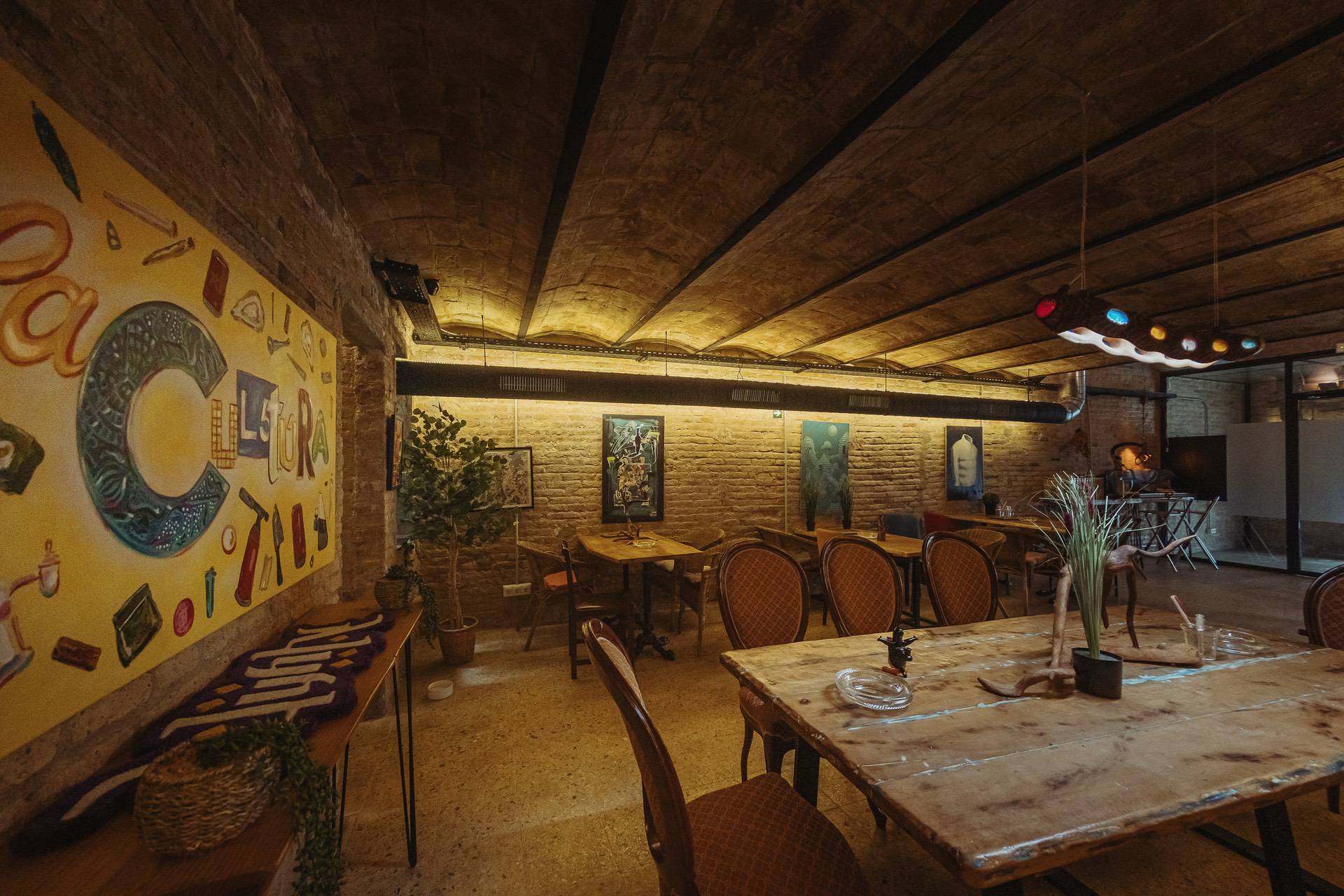 Interni creativi del club della cannabis Cultura Barcellona con murale e area lounge