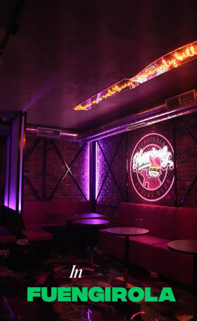 Video preview del Monopoly Social Club a Malaga, lounge con illuminazione rosa, muro di mattoni, tavoli rotondi e divani rosa imbottiti.  