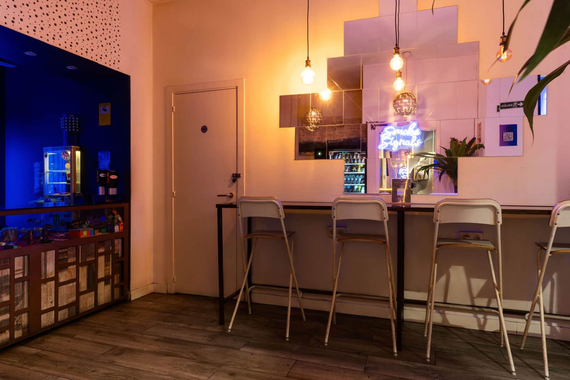 Bancone con specchi e insegna al neon nel cannabis club Smoke Signals Barcellona